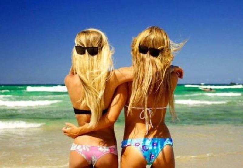 Две девушки - блондинка и брюнетка возле бассейна